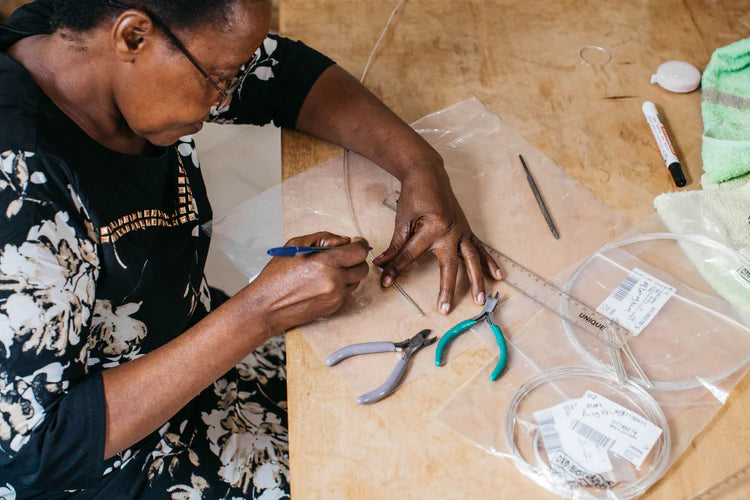 ugandan lady making jewellery at work bench